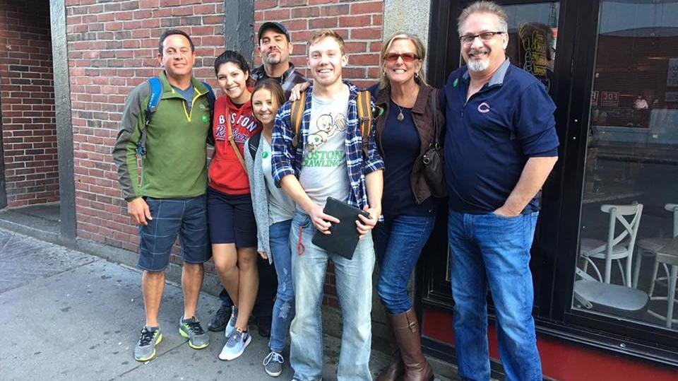 Joey Mantia et al. standing in front of a brick building