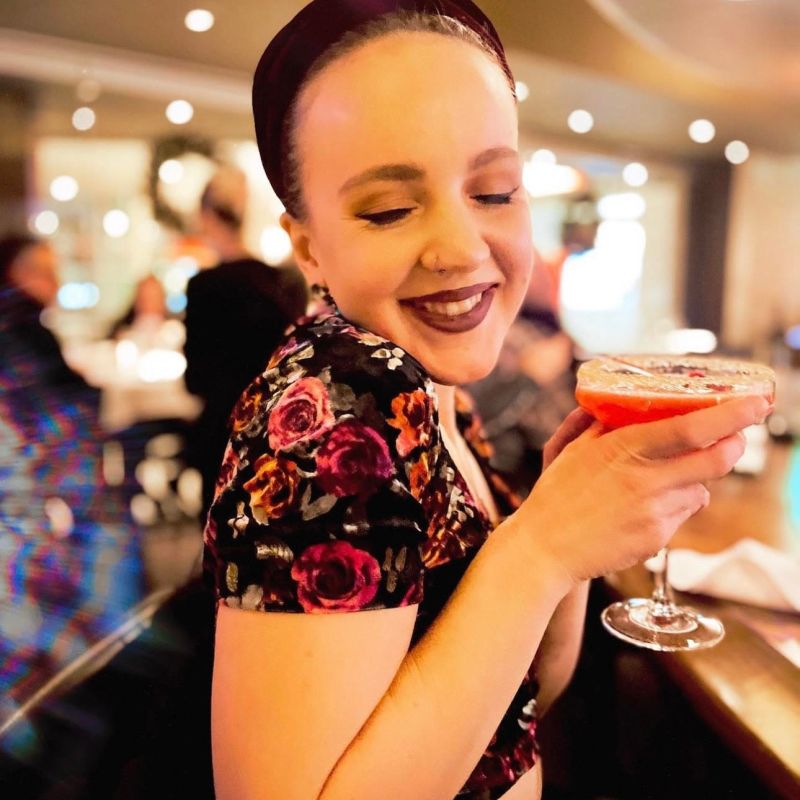 unnamed a woman sitting at a table with wine glasses